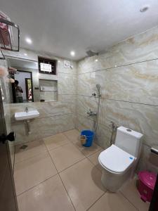 a bathroom with a toilet and a sink at Writer's Inn in Vaikom +36 photos