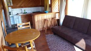 a living room with a couch and a table and a kitchen at Cabañas De Madera in La Unión