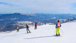 a group of people skiing down a snow covered slope at Apartment Mima Bjelasnica in Bjelašnica