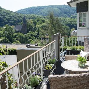 a balcony of a house with a table and flowers at Landhaus am Sonnenberg in Bad Bertrich