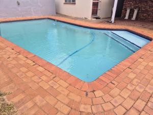 a swimming pool on a brick floor with a brickkeredkeredkeredkeredkeredkered at Charming Cottage for Getaways in Empangeni