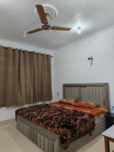 a bedroom with a bed with a ceiling fan at Hotel Sada Bahar in Srinagar