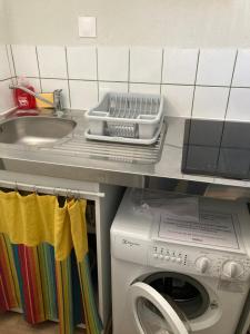 a kitchen counter with a washing machine and a sink at Morbreizh 1 in Paimpol