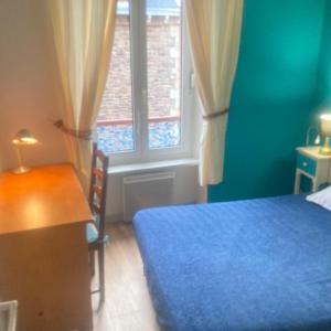 a bedroom with a blue bed and a window at Morbreizh 1 in Paimpol
