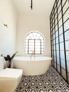 a bathroom with a white tub and a tile floor at La Casona in Guadalajara +50 photos