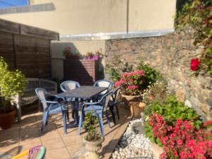 a patio with a table and chairs and flowers at Morbreizh 1 in Paimpol
