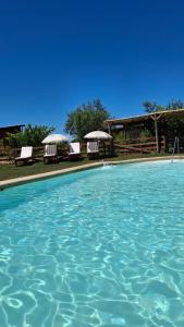 a swimming pool with some chairs and some water at Cabaña Refugio Magenta con tinaja caliente incluida in Ñipas