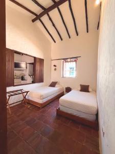 a room with two beds and a table in it at Casa Real Barichara in Barichara