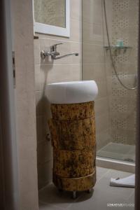 a bathroom with a sink on top of a wooden stump at Trakos Home Hotel in Korçë +28 photos