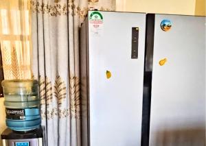 a container of water is sitting next to a refrigerator at Westerville Apartments in Kitengela 