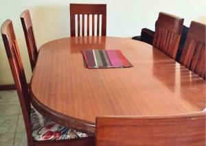 a wooden table with chairs and a napkin on it at Westerville Apartments in Kitengela 