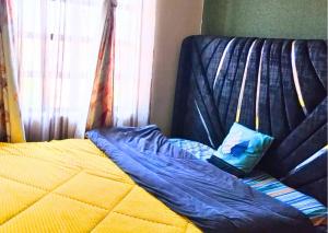 a bed with a blue comforter on top of it at Westerville Apartments in Kitengela 