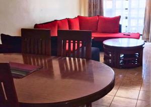 a living room with a table and a couch at Westerville Apartments in Kitengela 