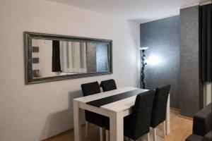 a white dining room table with chairs and a mirror at Apartman MARY in Belgrade