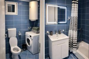 a blue tiled bathroom with a toilet and a sink at Apartman MARY in Belgrade