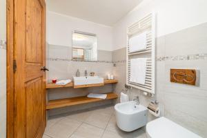 a white bathroom with a sink and a toilet at Maison Carrel Elegant 1 in Breuil-Cervinia +30 photos