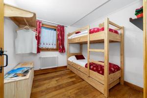 a bedroom with two bunk beds and a desk at Maison Carrel Elegant 1 in Breuil-Cervinia