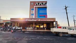 a white truck parked in front of a building at Hotel Madhur Pithampur in Akolia