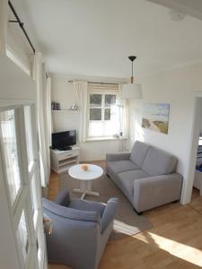 a living room with a couch and a table at Haus am Deich in Utersum