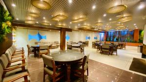 a restaurant with tables and chairs in a room at Hotel Madhur Pithampur in Akolia
