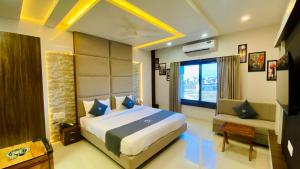 a bedroom with a large bed and a window at Hotel Madhur Pithampur in Akolia +68 photos