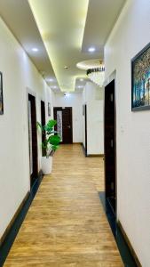 a hallway with white walls and a wooden floor at Hotel Madhur Pithampur in Akolia