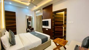 a bedroom with a bed and a television in it at Hotel Madhur Pithampur in Akolia