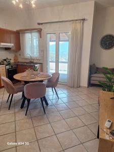 a kitchen and living room with a table and chairs at Kerkis View House in Karlovasi
