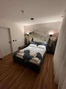 a bedroom with a large bed with a painting on the wall at Cabana Aurora in Topliţa