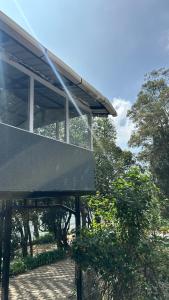 a building with a roof with trees in the background at Cloud Crest Homestay in Ooty