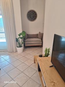 a living room with a couch and a clock on the wall at Kerkis View House in Karlovasi
