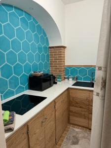 a kitchen with blue tiles on the wall at Casa Gallo in Cala Gonone +13 photos