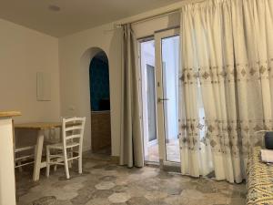 a living room with a table and a door to a kitchen at Casa Gallo in Cala Gonone