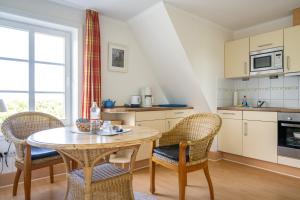 a kitchen with a table and chairs in a kitchen at Haus am Deich in Utersum