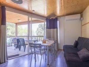 a living room with a couch and a table and chairs at ZEcamping 3 étoiles avec terrain multisports mini golf 2km plage dog friendly in Cargèse