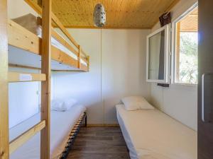 a room with two bunk beds and a window at ZEcamping 3 étoiles avec terrain multisports mini golf 2km plage dog friendly in Cargèse