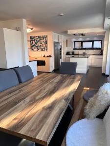 a living room with a wooden table and a kitchen at Villa Belmonte in Weilheim an der Teck