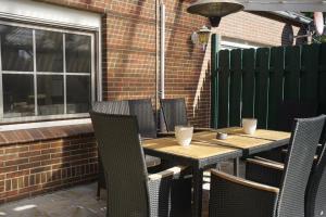 a wooden table and chairs on a patio at Ferienhaus Alex in Großefehn 