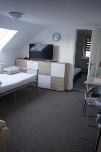 a room with a tv and a desk with a couch at Ferienhaus Alex in Großefehn 