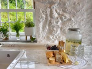 a tray of bread and a jar of food on a kitchen counter at Abrigos Baleeiros Turismo Rural in Feiteira +44 photos