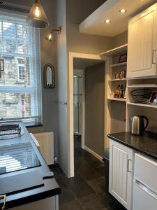 a kitchen with white cabinets and a counter top at Hidden Gem in Stirling