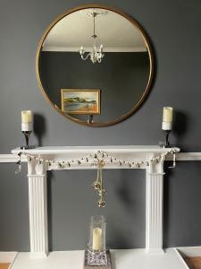 a mirror above a white console table with a candle at Hidden Gem in Stirling