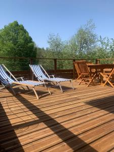 two chairs and a table on a wooden deck at Loulipo in Gerbépal