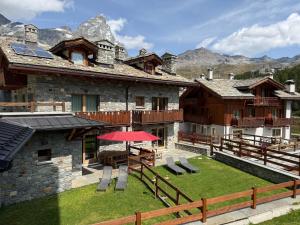 a house with a patio and a table and chairs at Maison Carrel Elegant 1 in Breuil-Cervinia