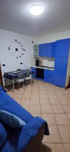 a room with a kitchen with blue cabinets and a table at Chiara Apartment in Cervignano with 2 Double Beds in Cervignano del Friuli