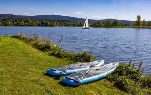 two canoes on the shore of a lake with a sailboat at Die Blaue Pause 29 in Weißenstadt