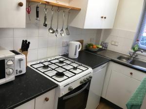 a kitchen with a stove top oven next to a sink at The River Flat in Oxford