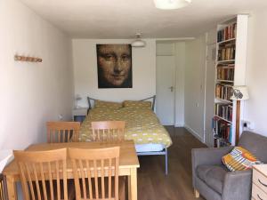 a living room with a table and a bed at The River Flat in Oxford