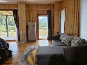 a living room with a couch and a refrigerator at บ้านพัก กามู Gamoo homestay in Chom Thong