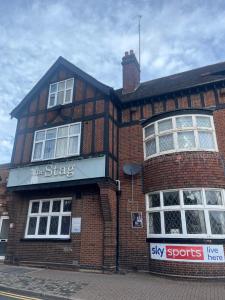 a brick building with a sign on the side of it at The Stag and Hen Pub in Coventry